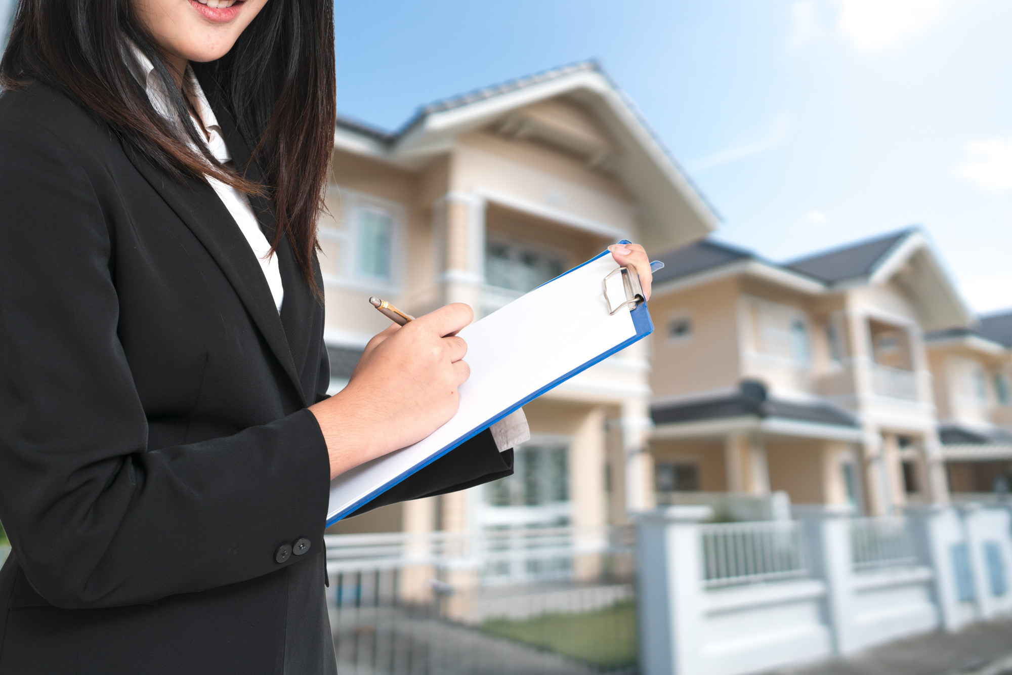 Young woman agent holding clipboard and pen.